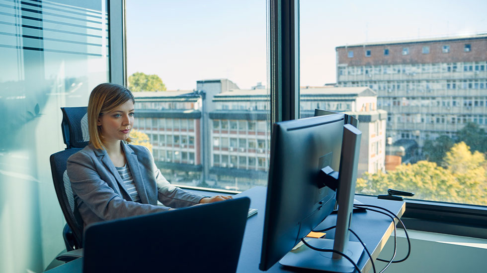 A woman working on a computer in an office.